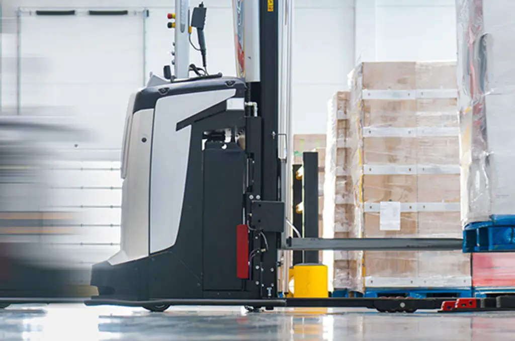 Un AGV trasporta un pallet in un magazzino per la movimentazione automatizzata dei materiali.