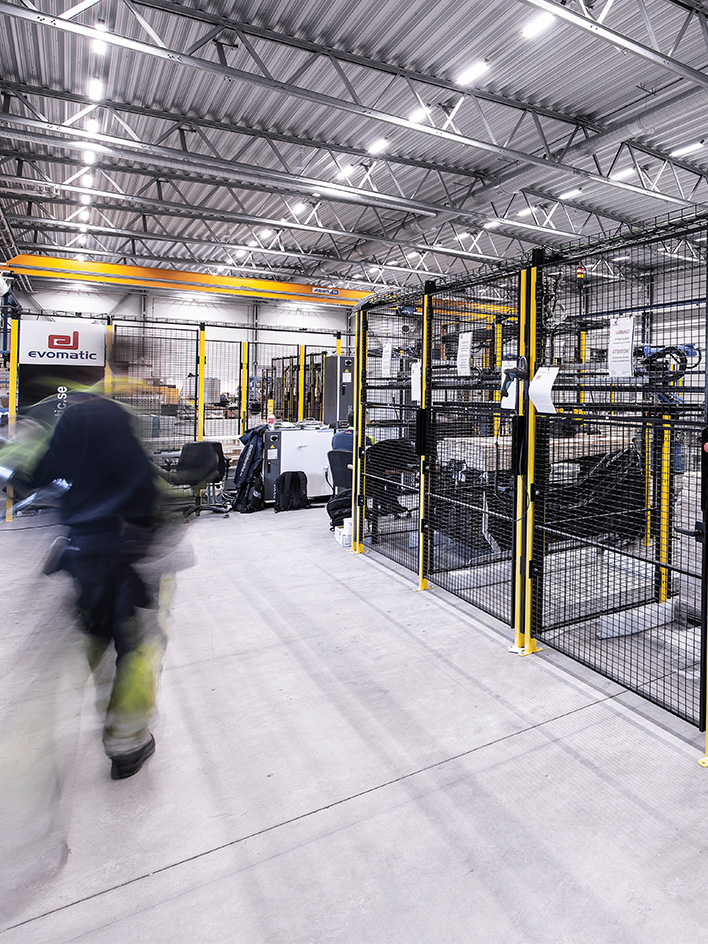 Macchine automatiche stazionarie per stoccaggio e confezionamento, inclusi nastri trasportatori, smistatori e pallettizzatori in un ambiente di magazzino.