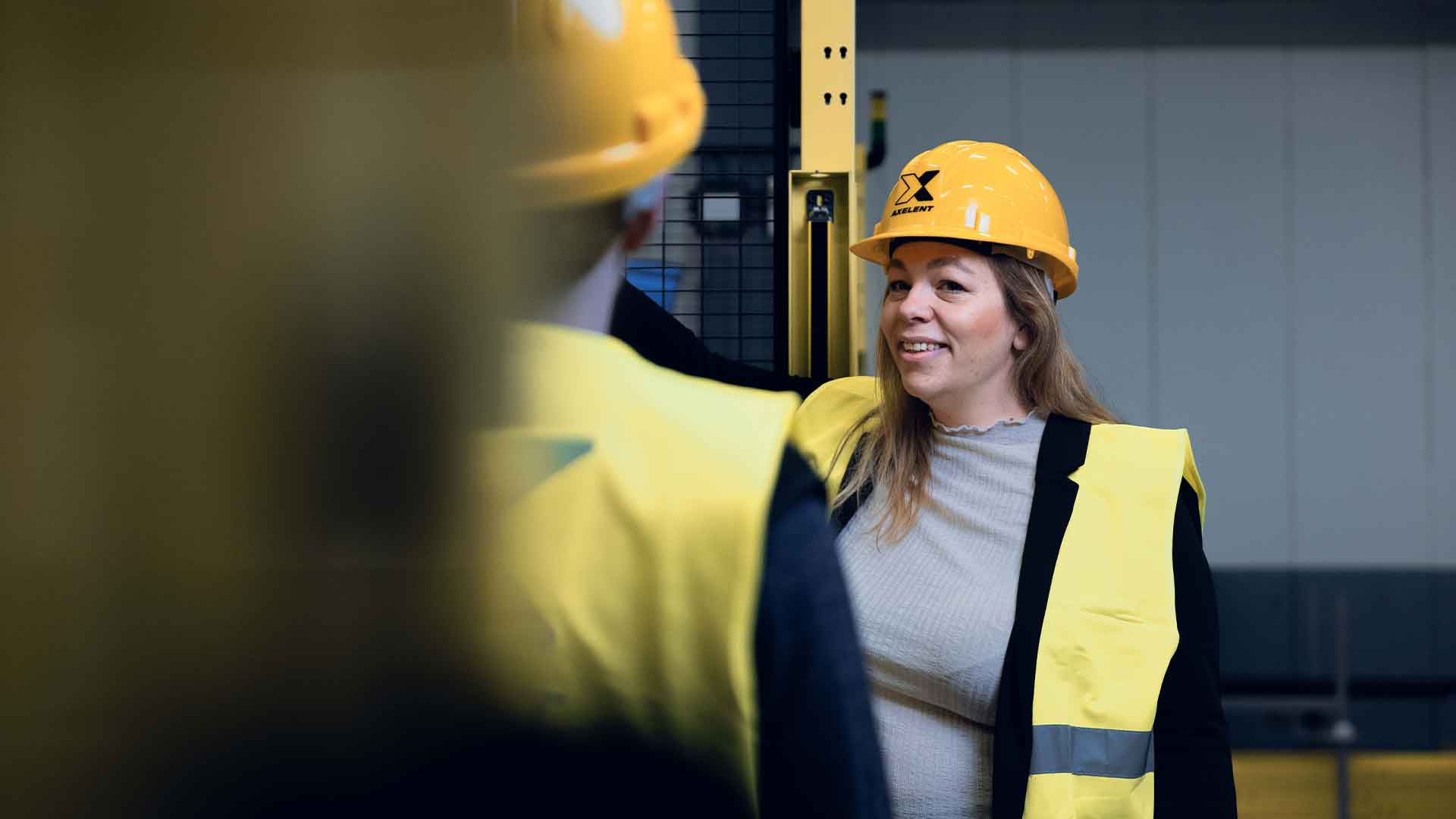 A woman talking and showing how to handle an industrial machine