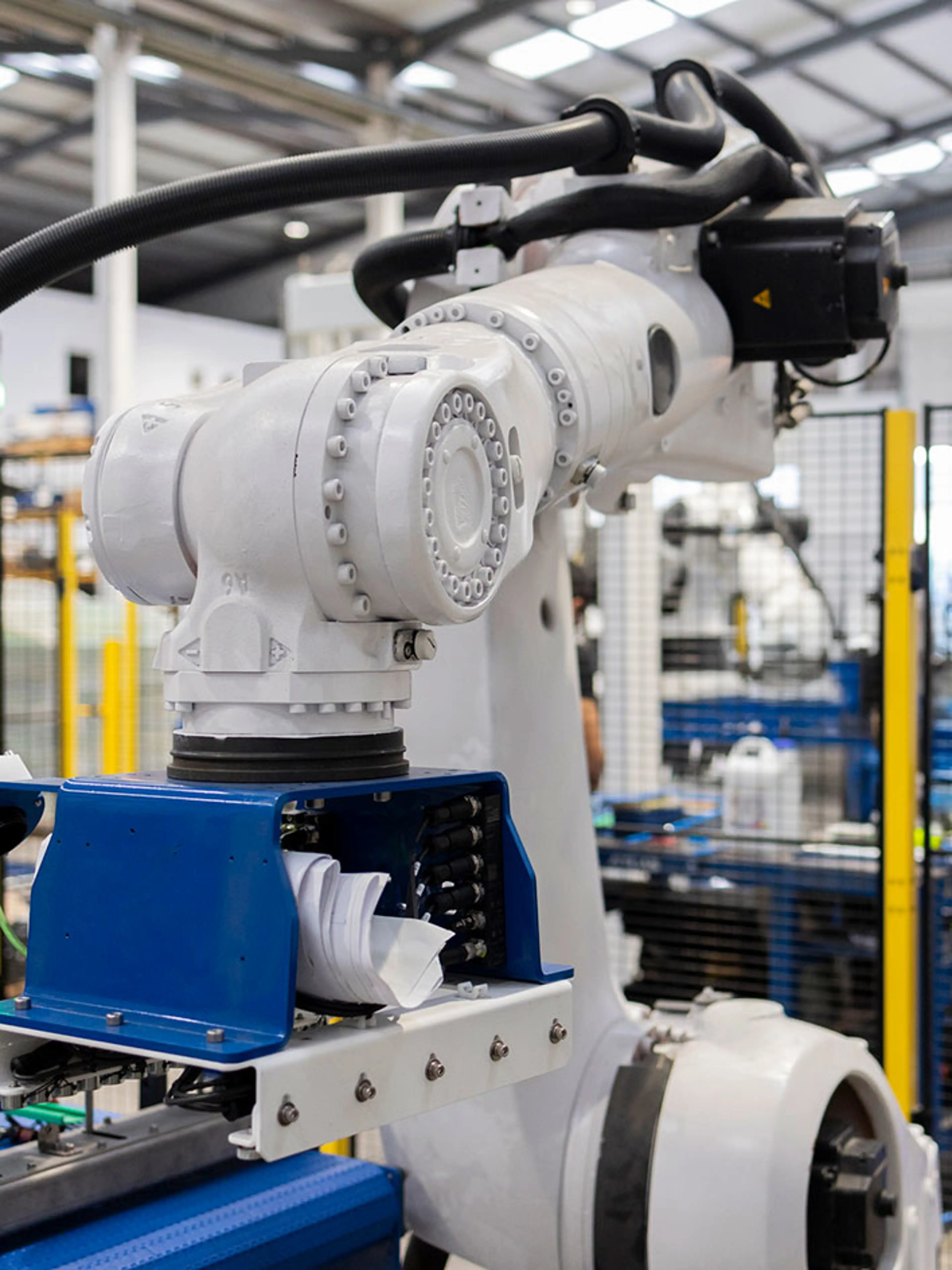 Robot collaborativo che posiziona i pacchi in un magazzino con barriere di sicurezza.