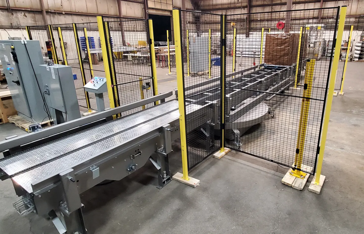 Protezioni perimetrali Axelent posizionate attorno ad un sistema di pallettizzazione in un grosso magazzino