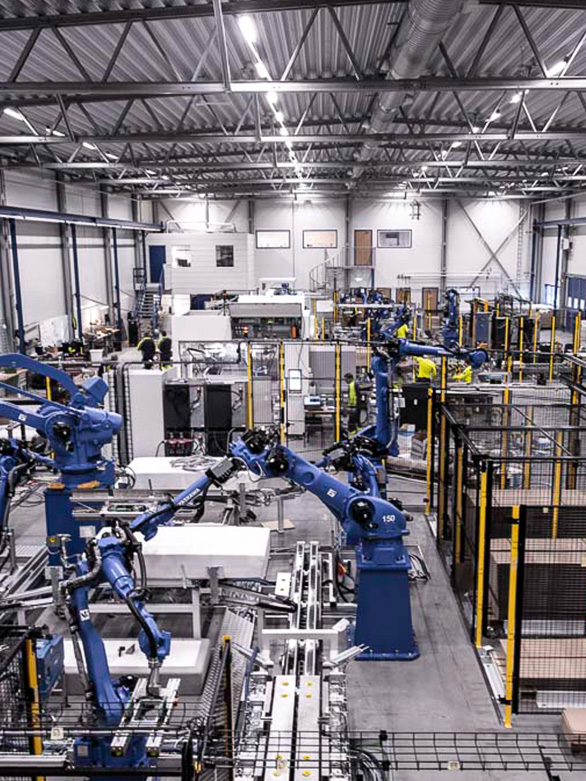 Macchinari di automazione fissa con punti di ingresso e uscita protetti per ridurre i rischi derivanti dal movimento delle merci.