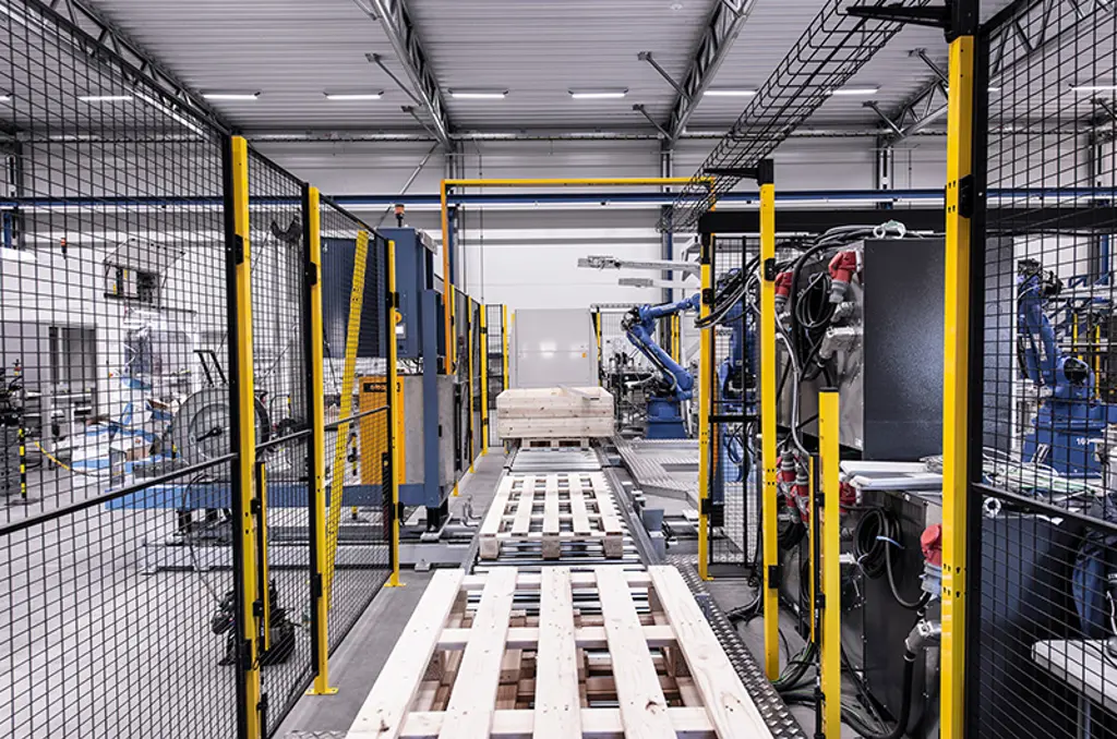 Linea di pallettizzazione automatizzata con bracci robotici e pallet in area di sicurezza